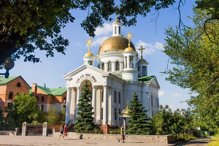 Logo of the OCU against the background of parishes of the Moscow Church